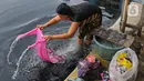 Warga mencuci pakaian di Kali Cilemahabang yang menghitam di kawasan Karangbahagia, Kabupaten Bekasi, Jawa Barat, Selasa (7/9/2021). Warga memanfaatkan aliran Kali Cilemahabang yang menghitam dan mengeluarkan bau tak sedap untuk mencuci baju hingga mandi. (Liputan6.com/ Herman Zakharia)