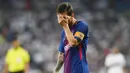 Striker Barcelona, Lionel Messi, menutup mukanya usai takluk dari Real Madrid pada laga Piala Super Spanyol 2017 di Stadion Santiago Bernabeu, Rabu (16/8/2017). Real Madrid menang 2-0 atas Barcelona. (AFP/Gabriel Bouys)