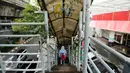 Warga menuruni tangga Jembatan Penyeberangan Orang (JPO) di Jalan Iskandarsyah, Jakarta, Selasa (1/11). Tampak kondisi atap JPO yang kotor dipenuhi coretan. (Liputan6.com/Helmi Fithriansyah)