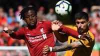 Striker Liverpool, Divock Origi, duel udara dengan gelandang Wolverhampton, Ruben Neves, pada laga Liga Inggris di Stadion Anfield, Liverpool, Minggu (12/5). Liverpool menang 2-0 atas Wolves. (AFP/Paul Ellis)