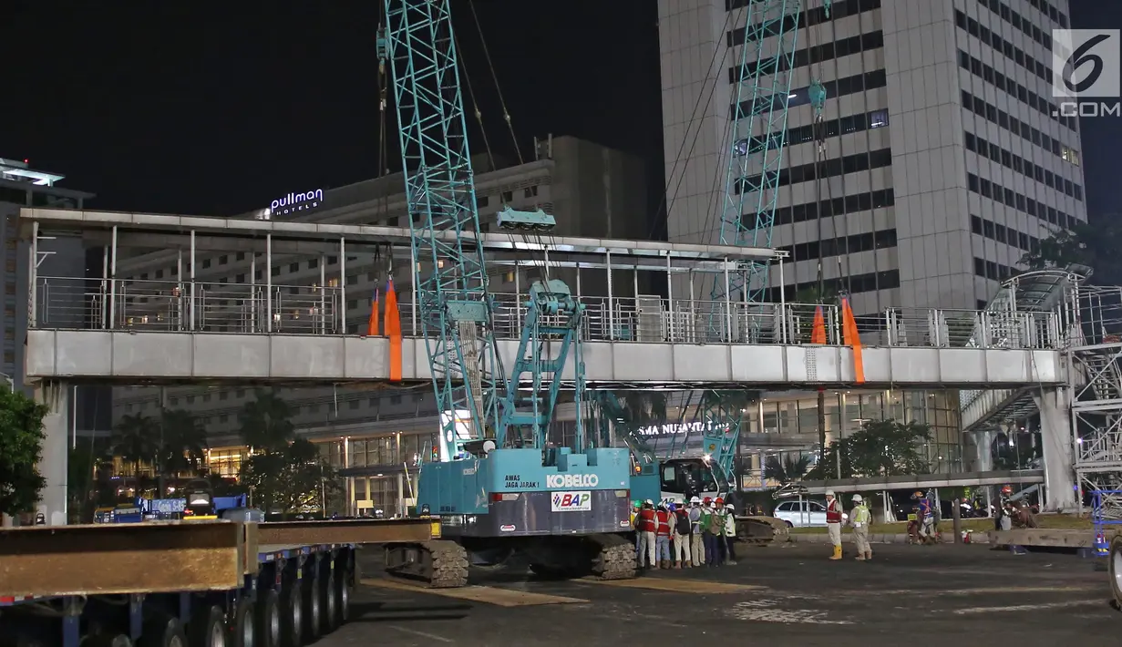 Petugas merobohkan Jembatan Penyeberangan Orang (JPO) di Kawasan Bundaran Hotel Indonesia, Jakarta, Senin (30/7) malam. JPO dirobohkan karena menghalangi pandangan ke patung Selamat Datang yang terletak di tengah bundaran HI (Liputan6.com/Herman Zakharia)