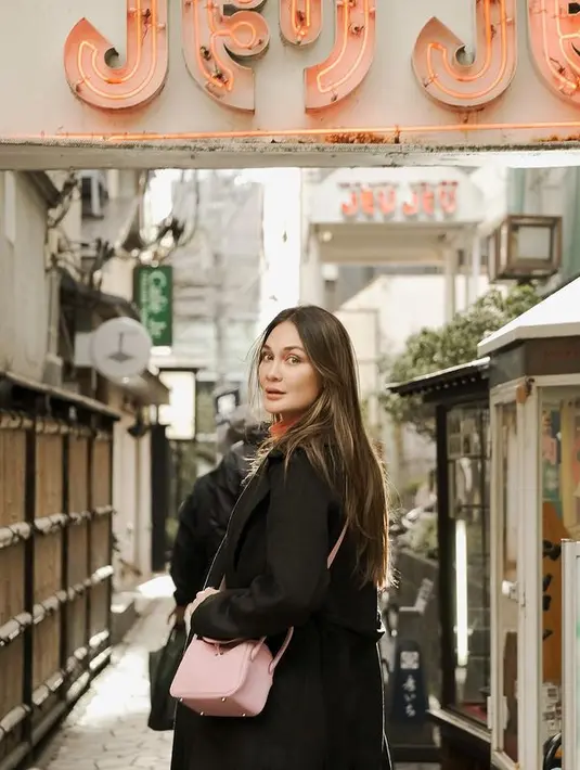 Luna Maya memulai perjalanannya di Jepang dengan outfit musim dingin. Memadukan turtleneck orange dengan loose jeans dan cashmere coat berwarna hitam. [instagram/lunamaya]