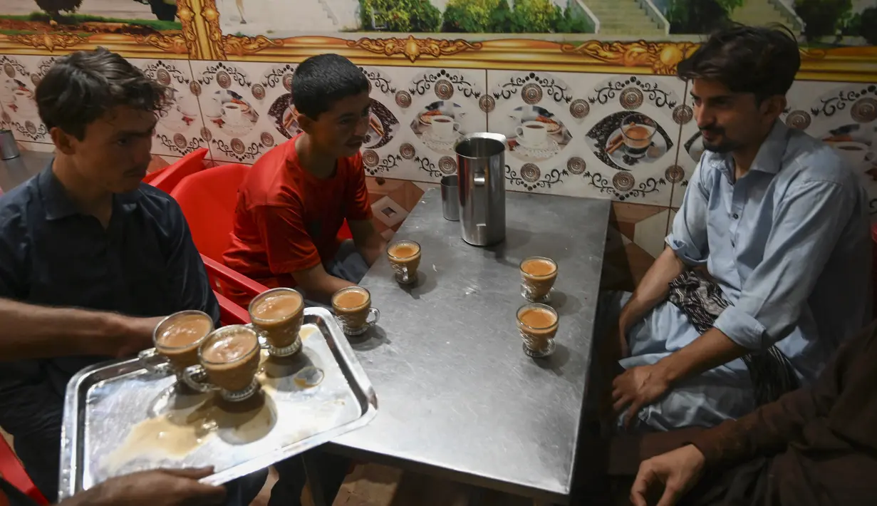 <p>Pramusaji menyajikan cangkir teh kepada pelanggan di sebuah restoran di Islamabad, Pakistan, Rabu (15/6/2022). Menteri Perencanaan Pakistan Ahsan Iqbal yang baru terpilih menghadapi kritik, menyusul permohonannya kepada warga untuk mengurangi minum teh guna membantu menghemat impor di tengah krisis ekonomi yang semakin dalam. (Aamir QURESHI / AFP)</p>