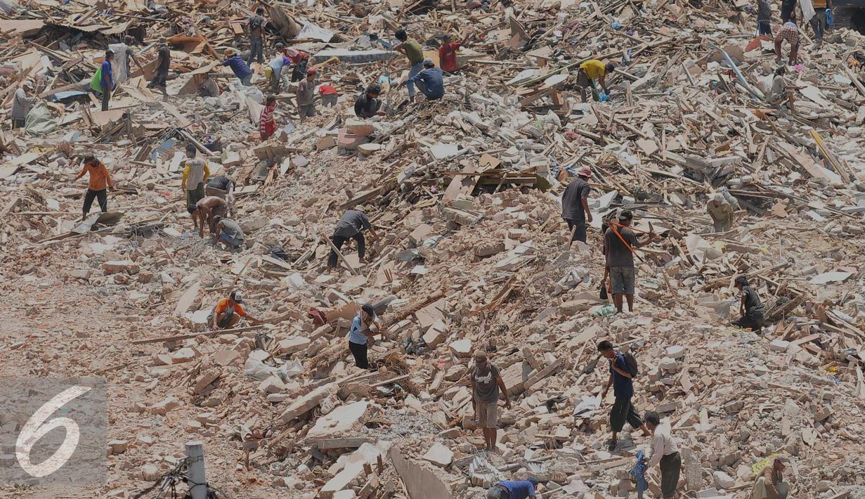 Warga mencari barang miliknya saat pembongkaran di kawasan Kampung Luar Batang, Jakarta (11/4). Sebanyak 853 bangunan di bongkar dalam rangka revitalisasi kawasan wisata Sunda Kelapa, Museum Bahari, dan kawasan Luar Batang. (Liputan6.com/Gempur M Surya)