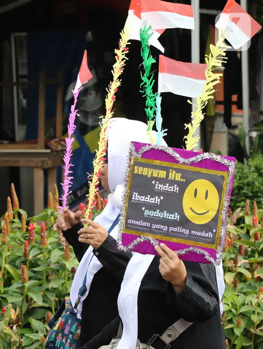 Peserta membawa poster saat mengikuti pawai mengelilingi Kawasan Pejambon dan Gambir di Jakarta, Sabtu (8/10/2022). Pawai tersebut diikuti ratusan peserta dari Madrasah Ibtidaiyah (MI), Madrasah Tsanawiyah Negeri (MTsN), Madrasah Aliyah dan perwakilan Majelis Taklim Istiqlal dalam rangka memperingati Maulid Nabi Muhammad SAW. (Liputan6.com/Herman Zakharia)