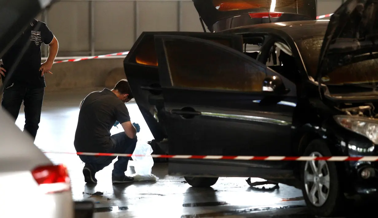 Polisi menyelidiki mobil yang ditinggalkan gangster terkenal Prancis, Redoine Faid di Aulnay-sous-Bois, utara Paris, Minggu (1/7). Faid terbukti mendalangi perampokan bersenjata pada 2010, di mana seorang polisi tewas. (AFP/GEOFFROY VAN DER HASSELT)