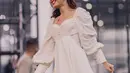 Nadin Amizah dengan dress vintage berwarna putih. Penampilannya di atas panggung terlihat manis dengan dress pendek berlengan panjang ini. [Foto: Instagram/cakecaine]