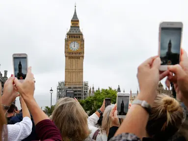 Sejumlah orang menggunakan ponsel merekam dentang terakhir Big Ben di Elizabeth Tower, London, Senin (21/8). Menara jam tersebut berhenti berdentang hingga empat tahun mendatang untuk renovasi besar-besaran di Gedung Parlemen. (AP Photo/Frank Augstein)