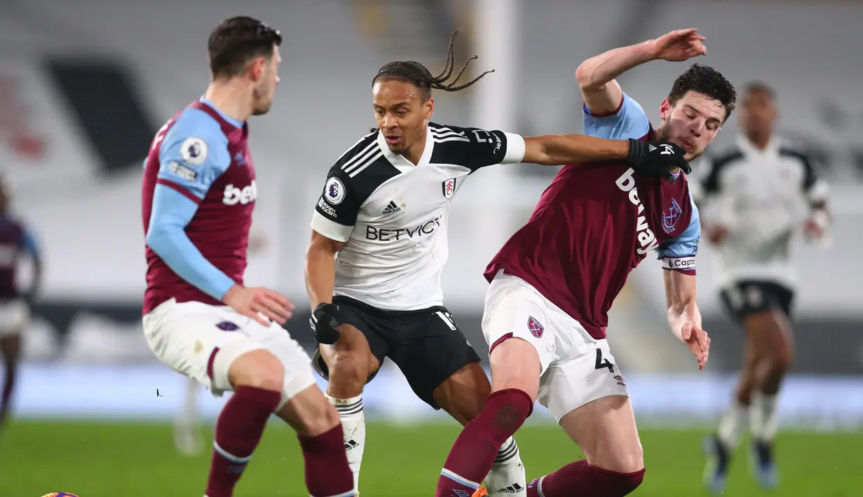 Striker Fulham, Bobby Decordova-Reid (tengah) dikurung dua pemain West Ham United, gelandang Declan Rice (kanan) dan bek Aaron Cresswell dalam laga lanjutan Liga Inggris 2020/21 pekan ke-23 di Craven Cottage, Sabtu (6/2/2021). Fulham bermain imbang 0-0 dengan West Ham United. (AFP/Adam Davy/Pool)
