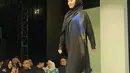 Gaya sederhana nan anggun Aaliyah Massaid dibalut gamis dan hijab pashmina serba hitam saat melenggang di fashion show brand modest milik Thariq Halilintar dan Harris Vriza, Thoiba Concept. [@rezaartemevia.official]