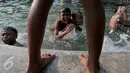 Sejumlah anak asik berenang dan bermain di kolam air mancur di kawasan Jalan Diponogoro, Jakarta, Jumat (31/7/2015). Minimnya lahan bermain di Ibukota, membuat mereka memanfaatkan kolam air mancur sebagai tempat berenang. (Liputan6/Johan Tallo)