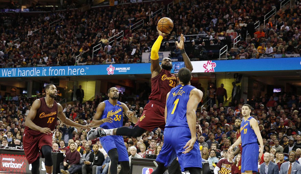Aksi LeBron James (23)  mencetak poi melewati hadangan para pemain Warriors pada laga NBA di Quicken Loans Arena, (25/12/2016). Cleveland menang 109-108. (Reuters/Brian Spurlock-USA TODAY Sports)