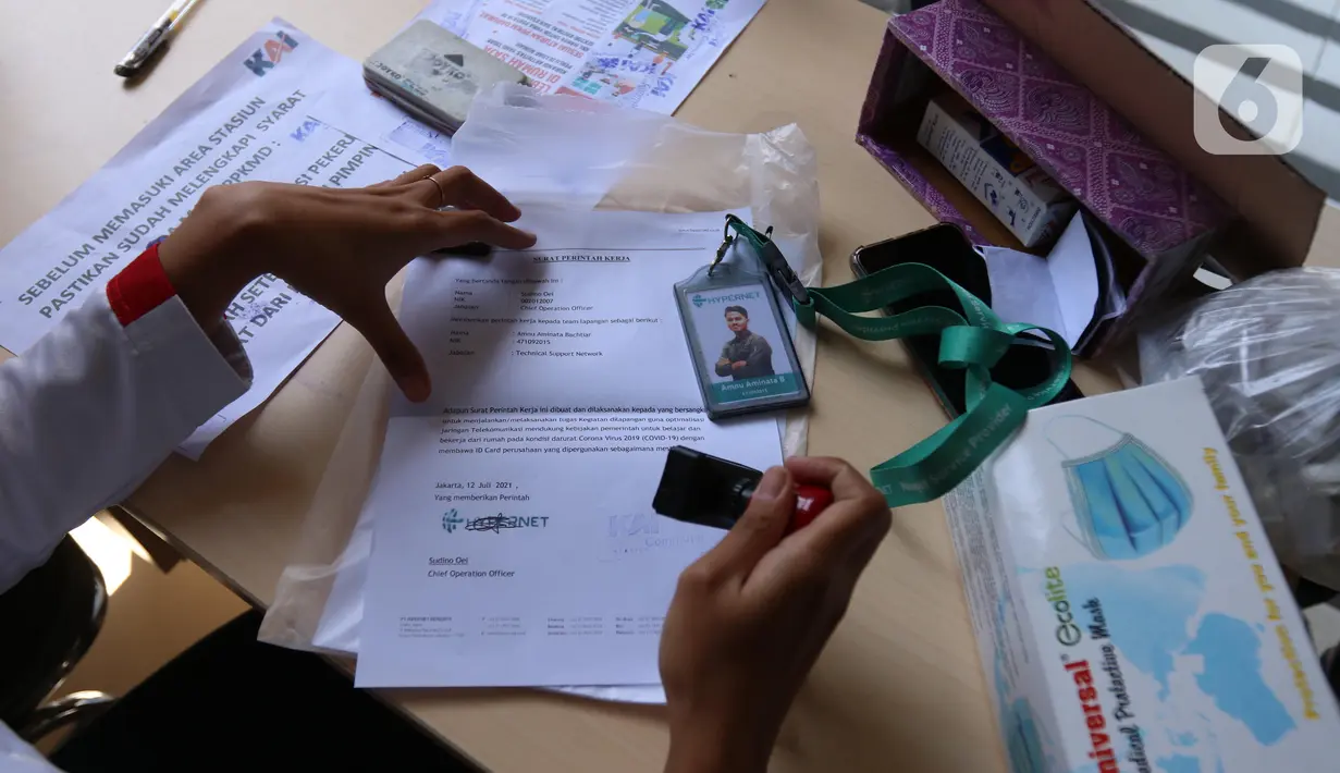 Petugas memeriksa Surat Tanda Registrasi Pekerja (STRP) bagi penumpang di Stasiun Tangerang, Banten, Senin (12/7/2021). Hari pertama penerapan STRP, masih ada warga yang tidak mengetahui persyaratan tersebut hingga membuat penumpang KRL menurun sekitar 30 persen. (Liputan6.com/Angga Yuniar)