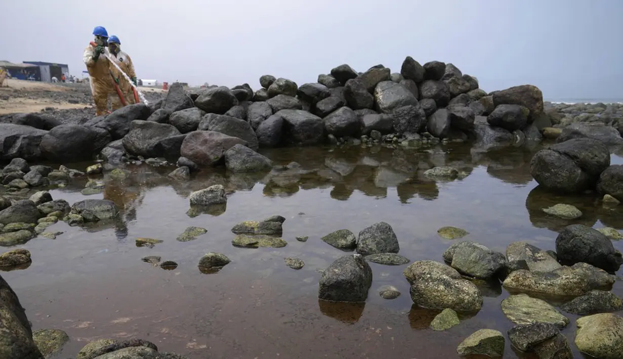 Pekerja melanjutkan kampanye pembersihan tumpahan minyak di Pantai Pocitos, Ancon, Peru, 15 Februari 2022. Sebulan berlalu, pekerja melanjutkan pembersihan di pantai setelah terkontaminasi tumpahan minyak Repsol. (AP Photo/Martin Mejia)