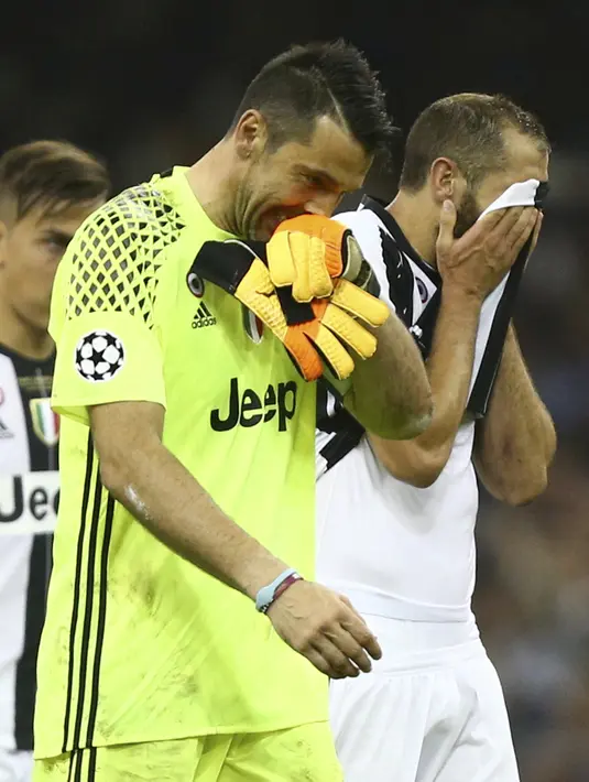 Gianluigi Buffon dam Giorgio Chiellini menutup wajah usai kalah dari Real Madrid pada Final Liga Champions di Millennium Stadium, Cardiff, Wales (3/6/2017). Juventus kalah 1-4. (AP /Dave Thompson)