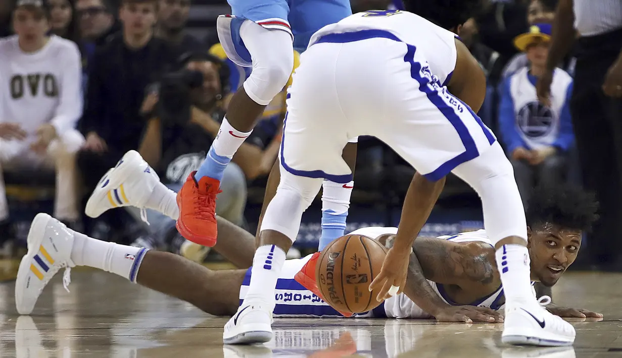 Pemain Warriors, Nick Young jatuh saat berebut bola dengan pemain Sacramento Kings pada laga NBA basketball game di Golden 1 Center, Oakland, California, (16/3/2018). King menang 98-93. (AP/Ben Margot)