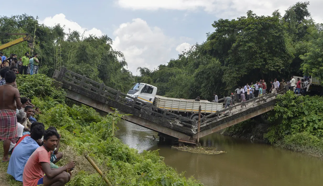 Penduduk desa berkumpul di dekat jembatan yang roboh di desa Phasidewa dekat perbatasan India-Bangladesh di pinggiran Siliguri di negara bagian India, Bengal Barat (7/9). Tidak ada korban dalam kejadian jembatan roboh tersebut. (AFP Photo/Diptendu Dutta)