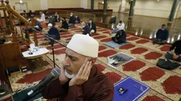 Yusuf Omar melakukan adzan sebelum melaksanakan tarawih pada malam pertama bulan suci Ramadhan di Pusat Komunitas Muslim Chicago, Senin (13/4/2021). (AP Photo/Shafkat Anowar)