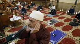Yusuf Omar melakukan adzan sebelum melaksanakan tarawih pada malam pertama bulan suci Ramadhan di Pusat Komunitas Muslim Chicago, Senin (13/4/2021). (AP Photo/Shafkat Anowar)