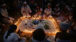 Pengikut kepercayaan Candomble Afro-Brasil menggelar ritual menyalakan lilin sebelum fajar saat perayaan Dewi Laut Yemanja di Salvador, Brasil (2/2). Mereka memberikan hadiah ke laut untuk persembahan kepada Dewi Laut Yemanja. (AP Photo / Eraldo Peres)