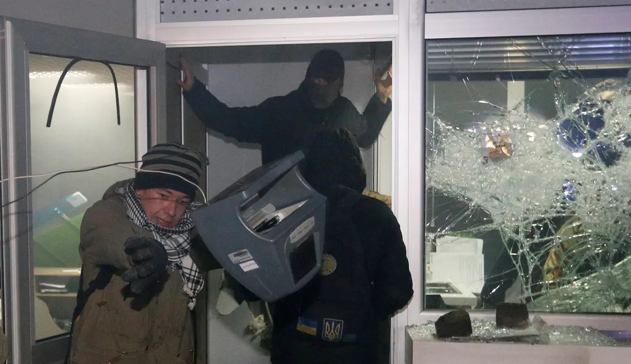 Para demonstran saat merusak fasilitas bank Rusia, Sberbank di Kyiv, Ukraina, (21/11). Selain menghancurkan bank massa memblokir lalu lintas dan membakar barang-barang di depan alun-alun. (REUTERS/Valentyn Ogirenko)