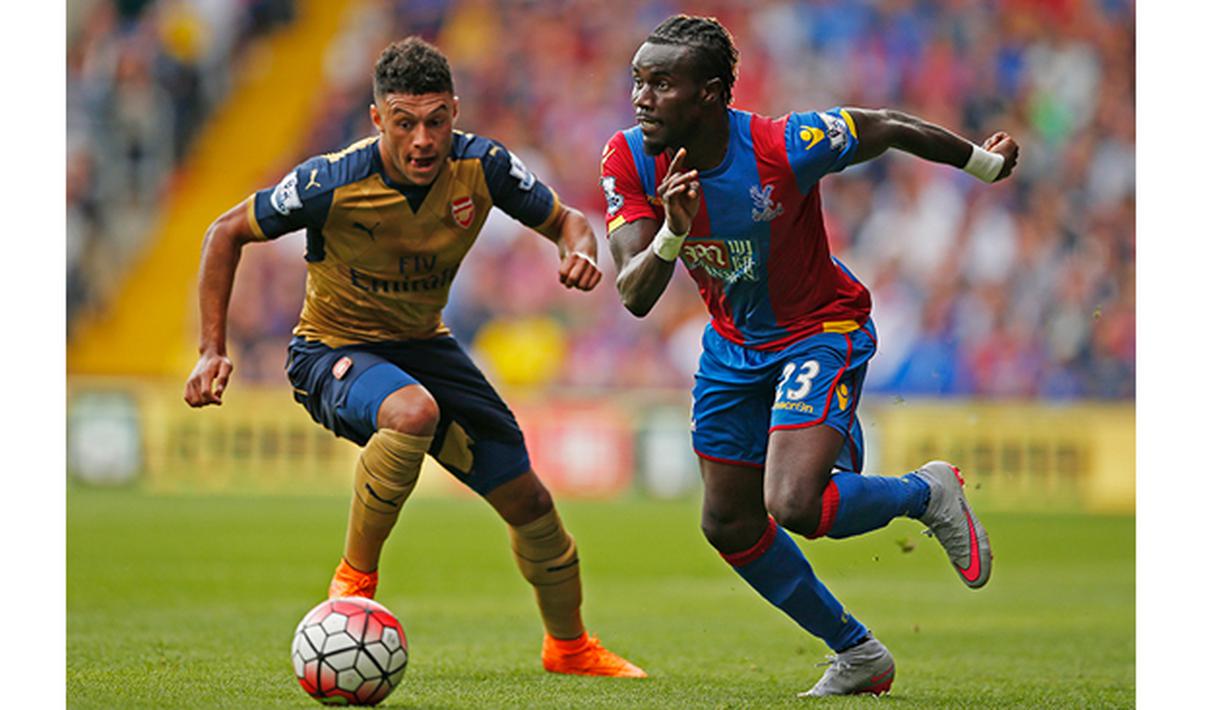 Bintang muda Arsenal, Oxlade Chamberlain berebut bola dengan pemain Crystal Palace, Pape Souare pada laga Liga Inggris di Stadion Selhurst Park, Inggris, Minggu (16/8/2015). Arsenal taklukan Palace 2-1. (Reuters/John Sibley)