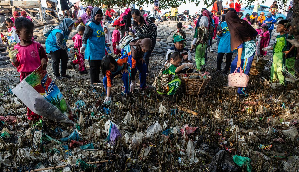 Anak-anak memungut sampah yang berserakan di sekitar kawasan pantai di Surabaya, Jawa Timur, Sabtu (21/9/2019).Aksi tersebut sebagai wujud kepedulian terhadap kebersihan lingkungan sekaligus dalam rangka memperingati World Cleanup Day 2019.  (JUNI KRISWANTO / AFP)