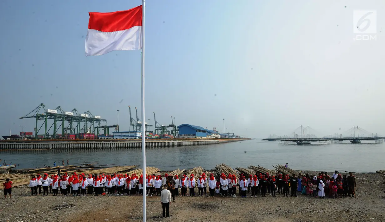 Warga pesisir pantai Cilncing melakukan upacara bendera HUT ke-74 Ri di pinggir pantai, RW 04, Cilincing, Jakarta Utara, Sabtu (17/8/2019). Kegiatan yang diikuti warga RW 08 Manunggal ini diprakarsai Kelas Jurnalistik Cilik dalam rangka memupuk  rasa kebangsaan. (merdeka.com/Arie Basuki)