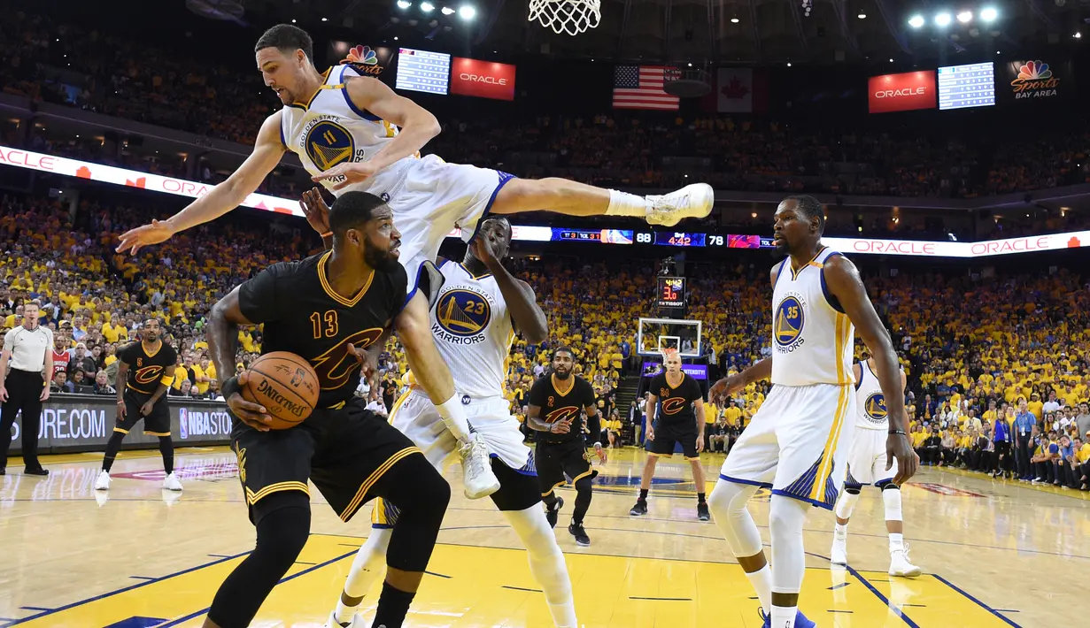 Klay Thompson melayang di udara saat mencoba menghentikan pemain Cleveland Cavaliers, Tristan Thompson dalam pertadingan gim kelima Final NBA 2017 di Oakland, California (12/6). (Kyle Terada/Pool Photo via AP)