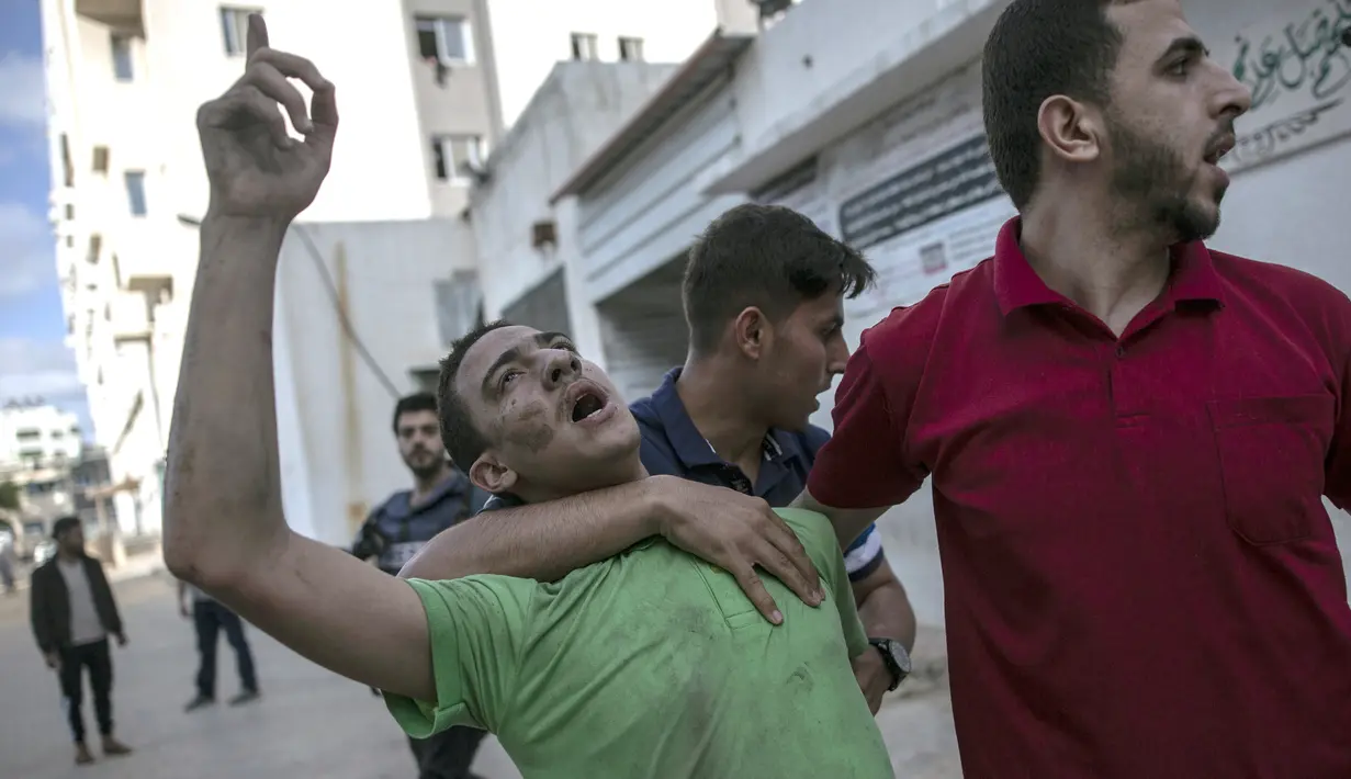 Seorang pria Palestina bereaksi terhadap kematian ayahnya dalam serangan udara Israel yang menghancurkan lantai atas sebuah bangunan komersial di Kota Gaza, Senin (17/5/2021). Tercatat ada 212 warga Palestina kehilangan nyawa di antaranya 61 korban merupakan anak-anak. (AP Photo/Khalil Hamra)