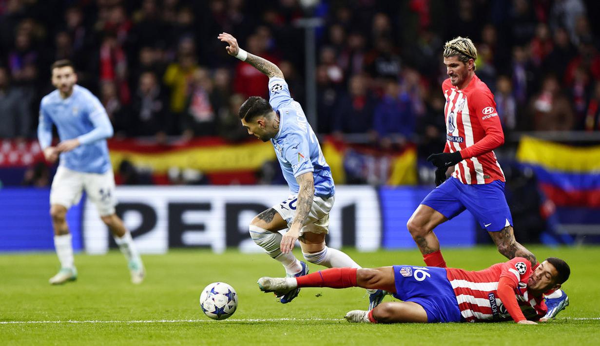 Pemain Atletico Madrid, Nahuel Molina, berusaha merebut bola dari pemain Lazio, Mattia Zaccagni, pada laga grup E Liga Champions di Stadion Metropolitano, Madrid, Kamis (14/12/2023). (AP Photo/Pablo Garcia)
