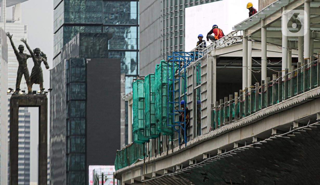 Pekerja menyelesaikan proyek revitalisasi Halte TransJakarta Bundaran HI, Jakarta, Senin (3/10/2022). Gubernur DKI Jakarta Anies Baswedan memastikan revitalisasi halte Transjakarta Tosari di kawasan Bundaran HI terus berlanjut. Proyek revitalisasi itu terus berlanjut meskipun sempat diprotes sejarawan JJ Rizal karena dianggap menutupi Patung Selamat Datang di Bundaran HI. (Liputan6.com/Faizal Fanani)