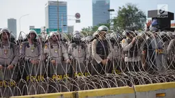 Aparat kepolisian berjaga di balik barikade kawat berduri saat unjuk rasa massa aksi dari elemen di depan Gedung DPR RI, Jakarta, Senin (30/9/2019). Aksi unjuk rasa tersebut menyikapi penolakan terhadap UU KPK dan sejumlah RUU yang dinilai bermasalah. (Liputan6.com/Immanuel Antonius)