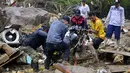 Warga mengangkat sepeda motor dari puing-puing setelah lereng bukit yang diguyur hujan runtuh menimpa rumah-rumah di Pereira, Kolombia, Selasa (8/2/2022). Hujan deras memicu tanah longsor menewaskan sedikitnya 14 orang dan melukai 35 lainnya. (AP Photo/Andres Otalvaro)