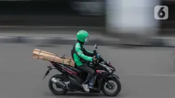Pengemudi ojek online membawa barang pesanan di kawasan Harmoni, Jakarta, Selasa (7/4/2020). Hal tersebut berdasarkan Permenkes Nomor 9 Tahun 2020 tentang Pedoman PSBB dalam Penanganan COVID-19. (Liputan6.com/Faizal Fanani)