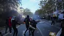 Sejumlah demonstran berdiri di depan sepeda yang terbakar saat aksi menentang kenaikan biaya hidup sekaligus menyuarakan tuntutan mahasiswa di Paris, Prancis, Sabtu (17/10/2026). (AP Photo/Thibault Camus)