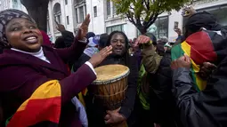 Warga Zimbabwe yang menetap di Inggris menggelar aksi protes di luar Kedutaan Besar Zimbabwe di London, Sabtu (18/11). Tak hanya menggelar long march, mereka juga menari dan minum bersama sambil menyerukan teriakan agar Mugabe mundur. (NIKLAS HALLE'N/AFP)