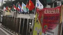 Deretan bendera negara-negara kontestan Asian Games 2018 yang terpasang menggunakan bambu di pagar pembatas Jalan Pluit Selatan Raya, Jakarta, Kamis (19/7). Bendera-bendera itu diikat di sebatang bambu yang dicat putih. (Liputan6.com/Arya Manggala)