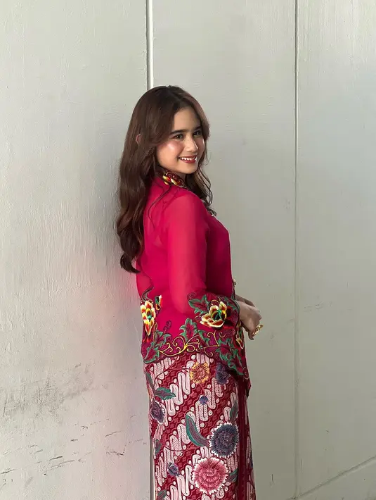 Tissa Biani memilih mengenakan kebaya encim bernuansa merah keunguan yang tak kalah cantik. Kebaya pilihannya memiliki detail bordir bunga besar di bagian depan, dipadunya dengan kain batik berwarna merah yang serasi dan selop bernuansa keemasan. [Foto: Instagram/tissabiani]