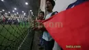 Suporter bernyanyi sambil menggulug bendera Merah-Putih raksasa di Tangerang, Sabtu (31/10/2015). Selain ingin mencatat rekor dunia, tema dasar adalah "One Soul, One Nation Untuk Sepakbola Indonesia".  (Bola.com / Nicklas Hanoatubun).