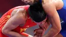 Pegulat putra Indonesia, Muhammad Aliansyah dan Zhang Gaoquan dari China saling mengunci saat bertarung pada kelas putra 67 Kg Asian Games 2018 di arena gulat JCC Senayan, Selasa (21/8). (Liputan6.com/Fery Pradolo)