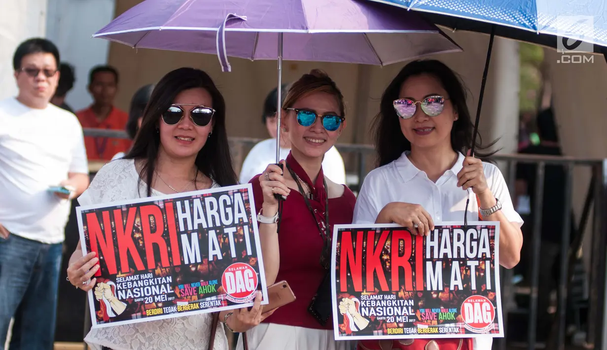 Penonton membawa poster saat hadir dalam Konser Kebangkitan Nasional di Waduk Pluit, Penjaringan, Jakarta Utara, Sabtu (20/5). (Liputan6.com/Gempur M. Surya