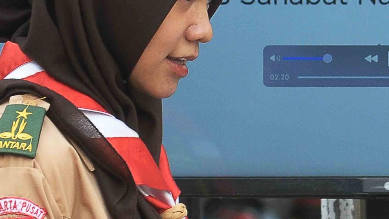 Pelajar anggota Pramuka peserta Raimuna Nasional (Rainas) XII Tahun 2023 sedang melihat brosur  lembaga Penjamin Simpanan (LPS) di Buperta, Jakarta Minggu (20/8/2023).