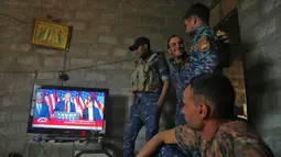 Para pasukan Irak terlihat serius menonton siaran pidato kemenangan Donald Trump saat terpilih menjadi Presiden AS di Desa Arbid, Mosul (9/11). Di tengah perang melawan ISIS, mereka menyempatkan menonton pidato Donald Trump.(AFP PHOTO/Ahmad Al-Rubaye)