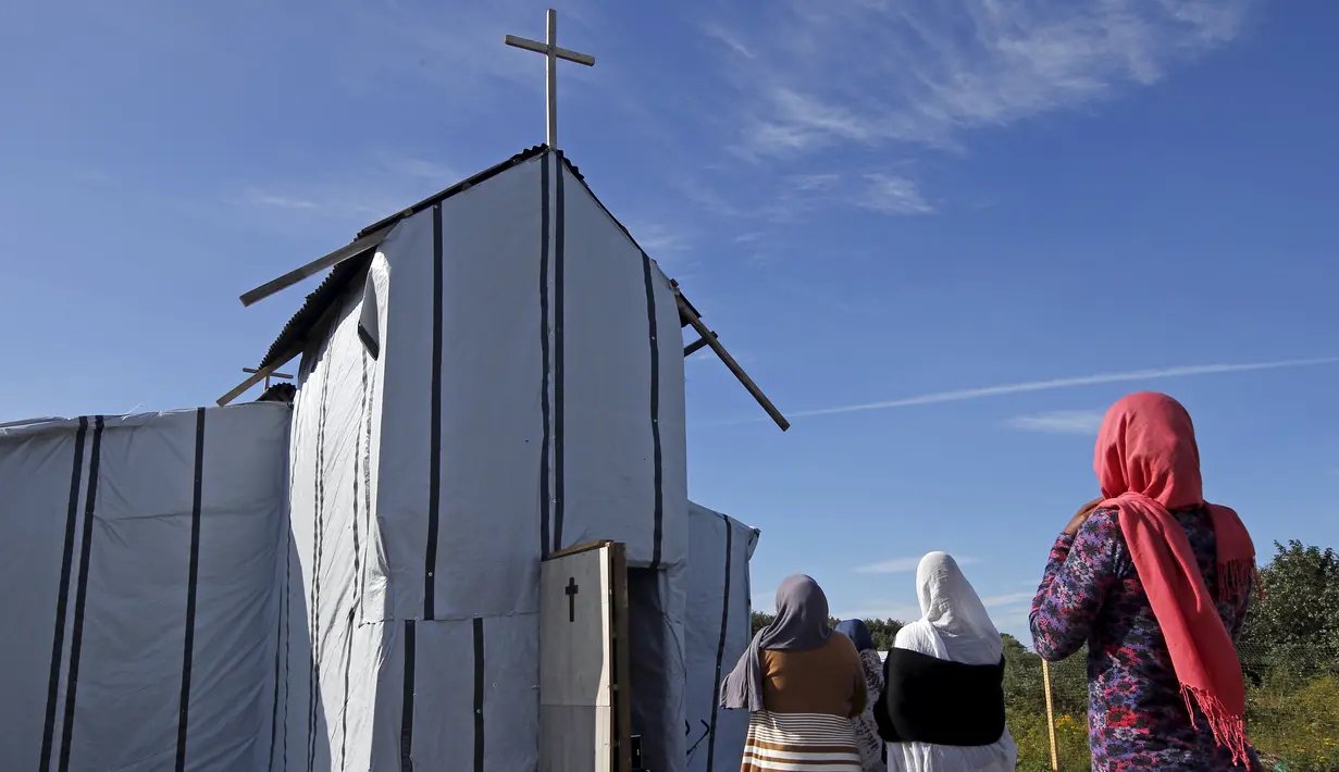 Imigran gelap tiba di sebuah gereja darurat yang di dirikan di dekat kamp sementara mereka di sekitar pelabuhan Calais, Prancis, Minggu (2/8/2015). Sebelumnya, ratusan imigran memaksa masuk Prancis melalui Terowongan Channel. (REUTERS/Pascal Rossignol)