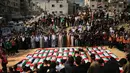 Warga Palestina berkumpul di sekitar jenazah warga Palestina yang tewas dalam serangan Israel selama perang dengan Hamas setelah ditemukan dari bawah reruntuhan bangunan. Jenazah yang dibungkus bendera Palestina tersebut dibawa dalam prosesi pemakaman di Kota Gaza, Kamis (1/10/2026). Keluarga dan warga setempat berkumpul untuk memberikan penghormatan terakhir kepada para korban dalam suasana duka. (AP Photo/Yousef Al Zanoun)