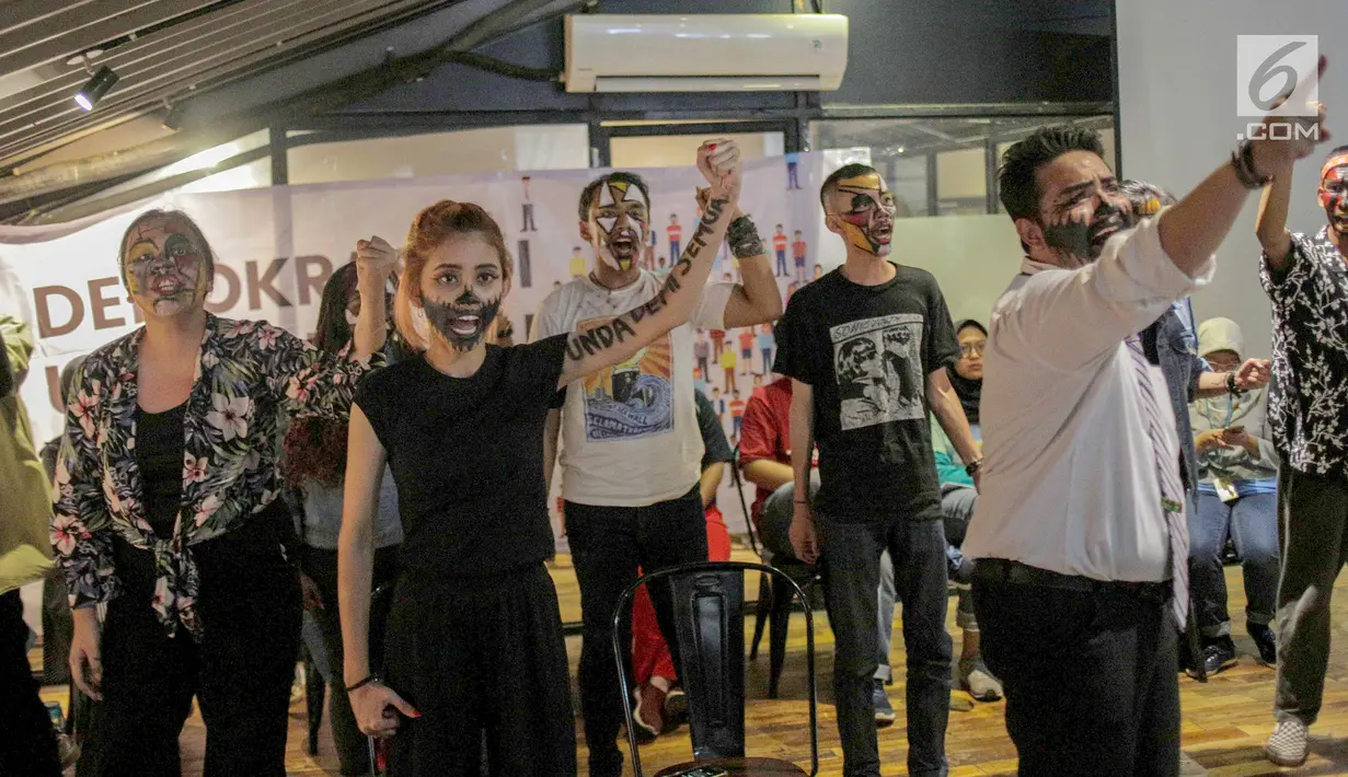 Mahasiswa dari Semalam Theater Group menampilkan aksi teatrikal saat konferensi pers bertajuk Demokrasi di Ujung Tanduk, Jakarta, Minggu (15/9/2019). Konferensi pers ini diadakan dalam rangka peringatan Hari Demokrasi Internasional. (Liputan.com/Faizal Fanani)