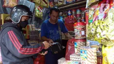 Pedagang kue kering melayani pembeli di salah satu toko di kawasan Ciracas, Jakarta, Kamis (19/4/2023). (Liputan6.com/Herman Zakharia)