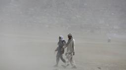 Pria Afghanistan berjalan saat badai pasir di pinggiran Kabul, Afghanistan (25/8/2020). Sebuah badai pasir hebat melanda Kabul. Badai menyebabkan jarak pandang jadi berkurang. (AP Photo / Rahmat Gul)