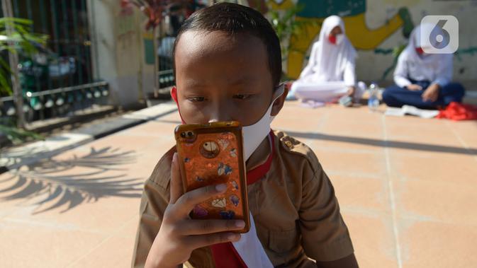 Siswa belajar di kolong rel kereta api Mangga Besar, Jakarta,Rabu (19/8/2020). Proses belajar siswa tersebut menggunakan modem paket internet wifi gratis yang disediakan untuk mengikuti pembelajaran jarak jauh. (merdeka.com/Imam Buhori)